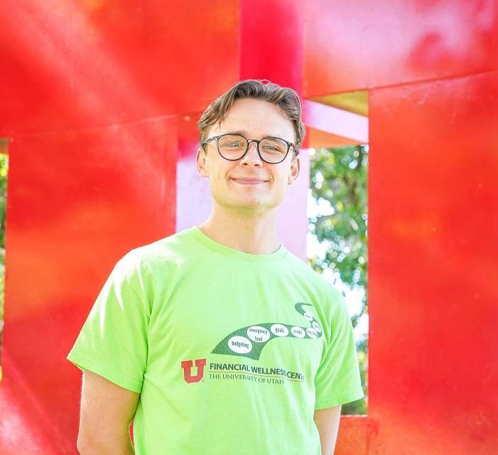 alex wearing green shirt standing in front of block u