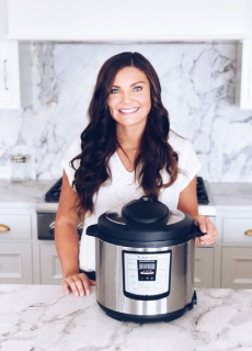 Alex Daynes is standing behind a counter with an instant pot on the counter. 