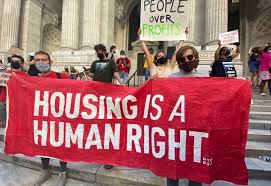 protestors with signs saying housing is a human right