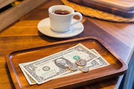 coffee cup on table with money for tip