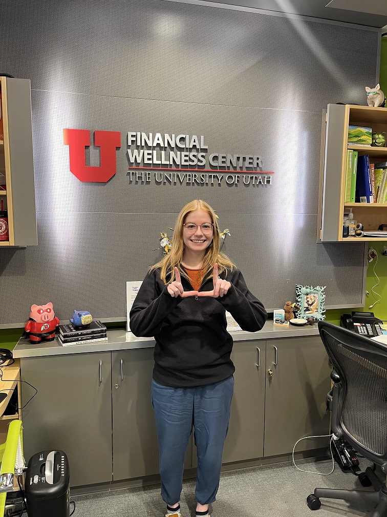 Elsa in front of the financial wellness center logo sign