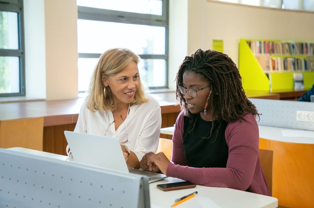student and professor sitting next to each other talking